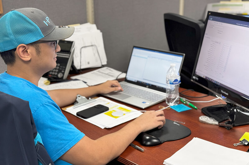 I-PEX staff working at a desk, reviewing data on a computer