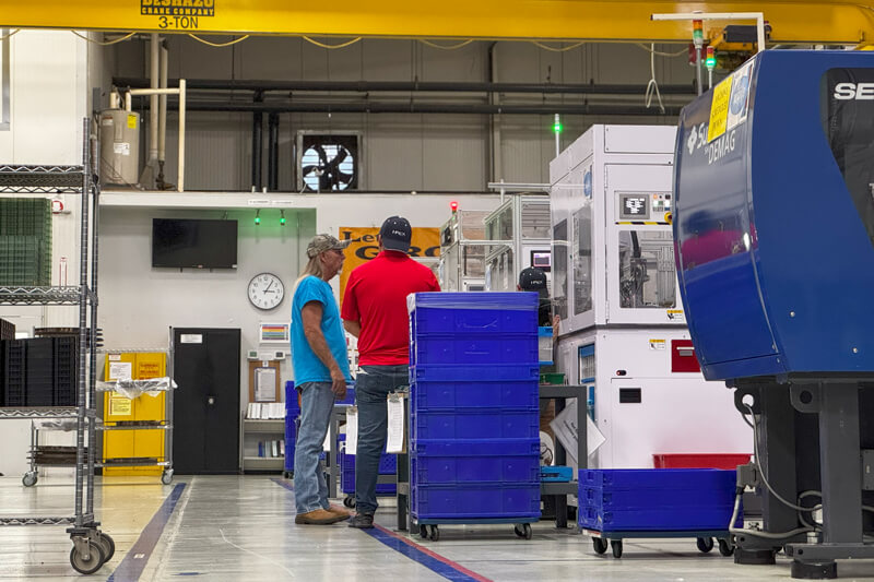 I-PEX staff inspecting machinery in the production area