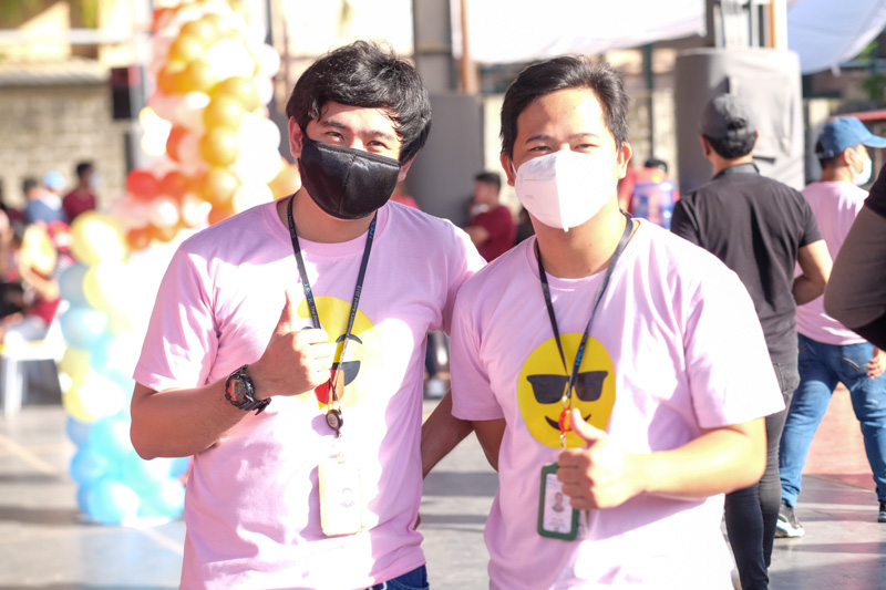 Employees performing a cultural dance on an outdoor stage