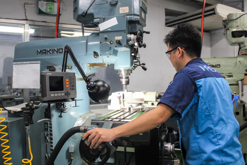 Employee operating a machining tool in a manufacturing environment