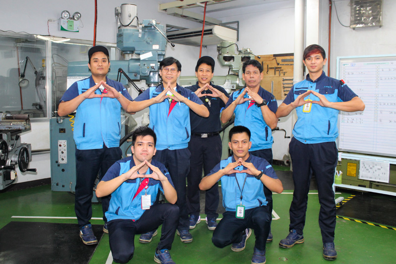 Employees striking the Sharpest pose with their hands in a triangle