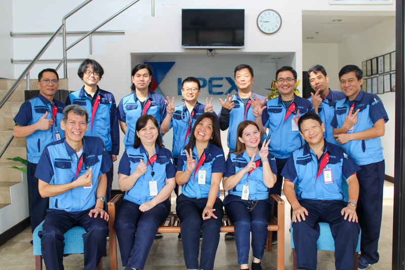 Group photo of I-PEX Philippines Inc. employees gathered in an office area