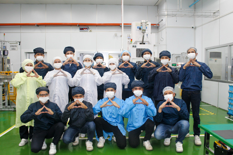 Employees striking the Sharpest pose with their hands in a triangle with masks