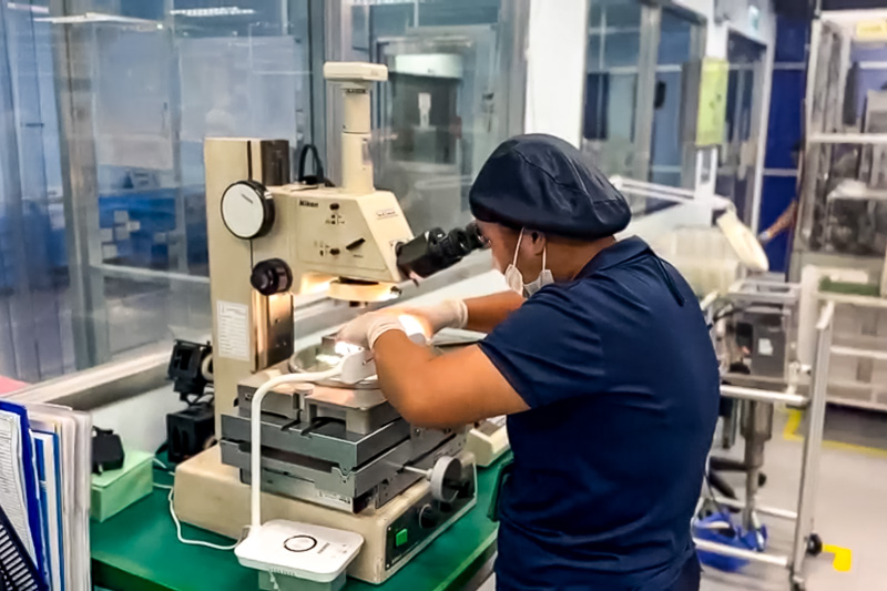 Employee performing precision work using inspection equipment