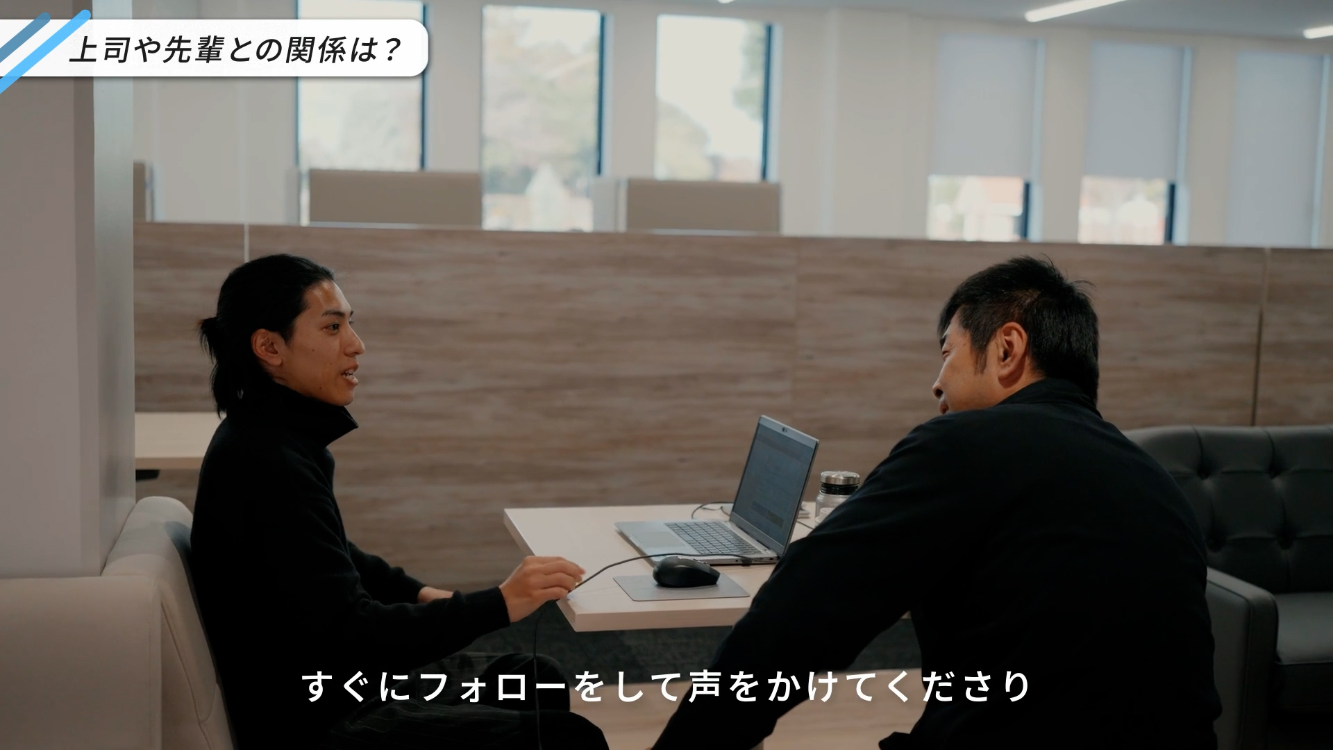 調達のKさんが「自分から助けを求める前に、上司や先輩がすぐにフォローしてくださる」と語り、上司と談笑している様子