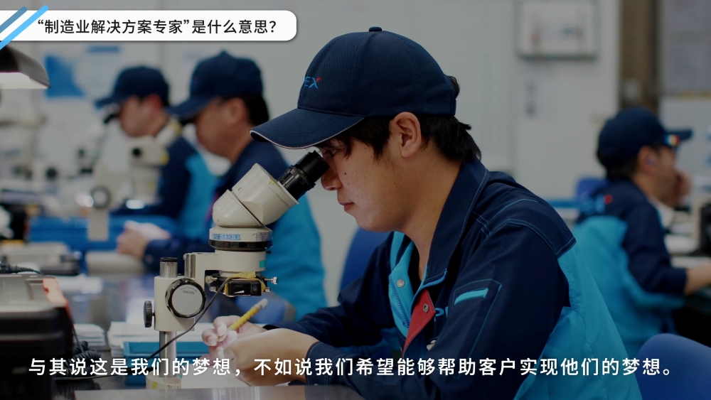 "通过制造製造,成就客户的梦想"的标语，以及I-PEX员工在工厂里透过显微镜进行作业的情景