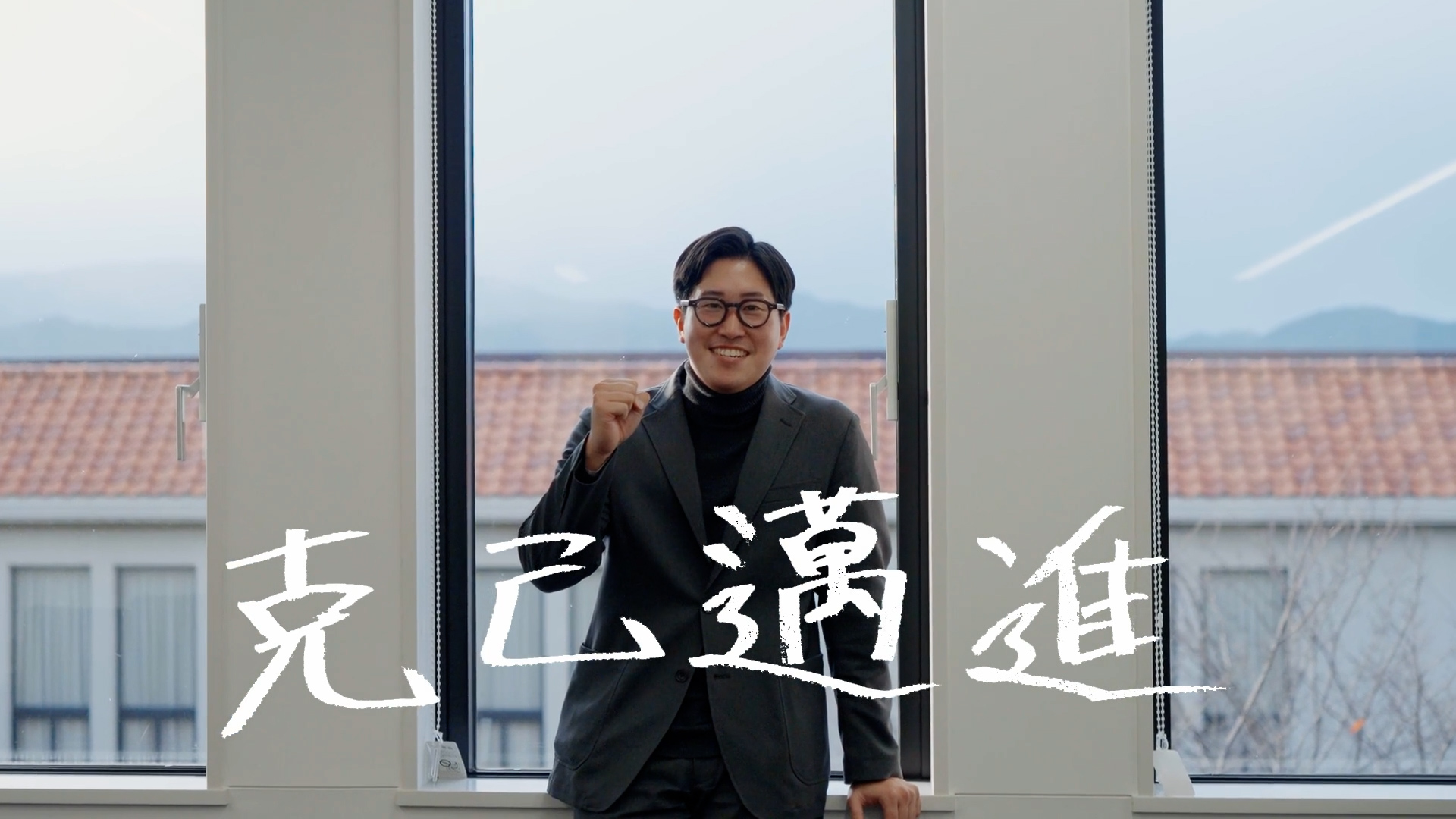 人事のMさんが大切にしている「克己邁進」という言葉とともに笑顔を見せる様子