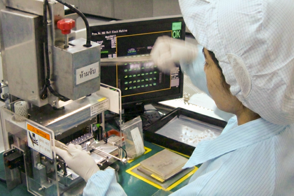Worker checking the control panel of manufacturing equipment