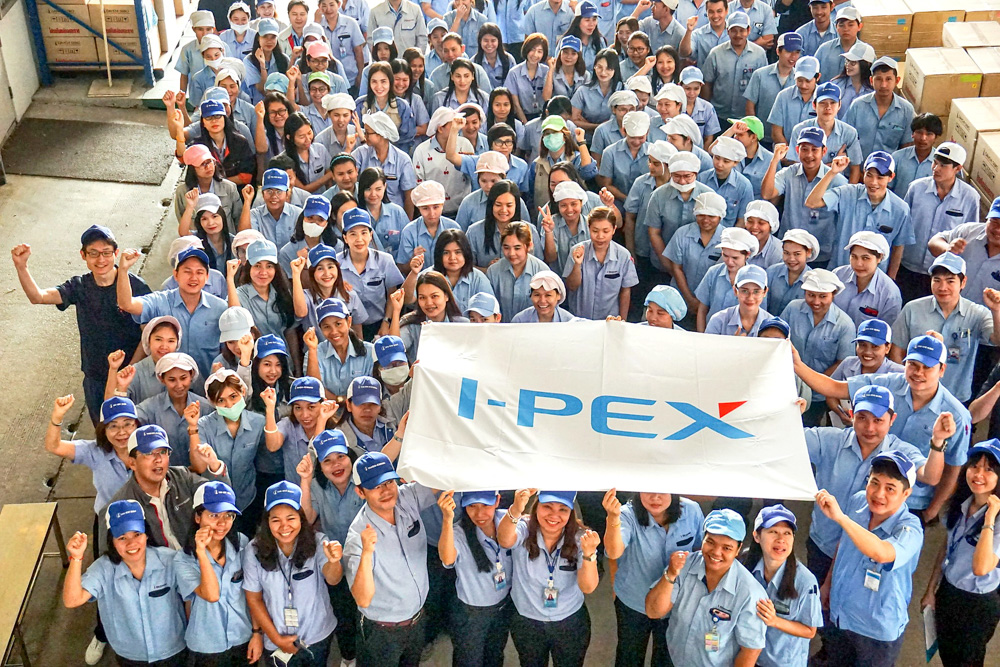 I-PEX Thailand employees gathered with an I-PEX flag