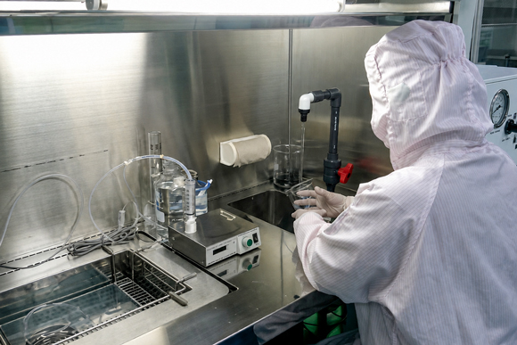 I-PEX Thailand worker conducting product testing in a cleanroom environment